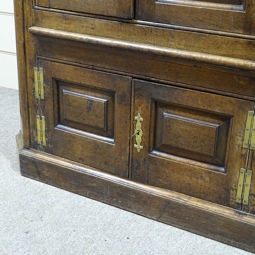 326 - An 18th century floor standing panelled oak corner cupboard, with fluted corners