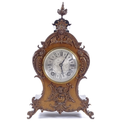 433 - A late 19th century mantel clock with allover ornate cast-brass moulding and mounts, engraved silver... 