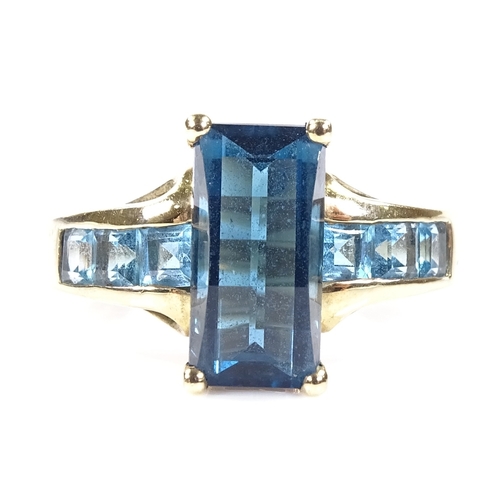 554 - A 9ct gold blue topaz dress ring, with topaz set openwork shoulders, setting height 12.9mm, size T, ... 