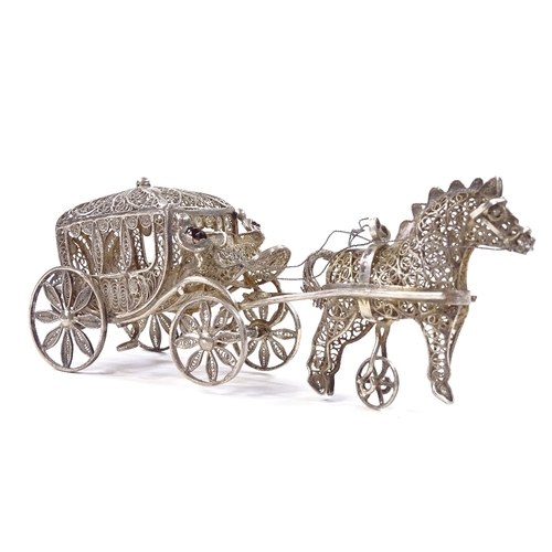 653 - A Maltese unmarked silver filigree horse-drawn carriage model, rotating wheels and stone set lantern... 