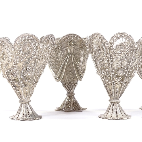 654 - A set of 6 Maltese unmarked silver filigree egg cups, two of each design, with pierced and woven dec... 