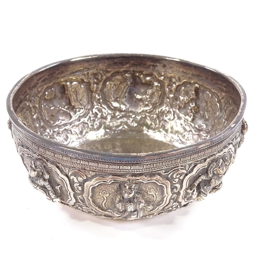 675 - A small Burmese unmarked white metal Thabeik bowl, high relief figural and lotus decoration with eng... 