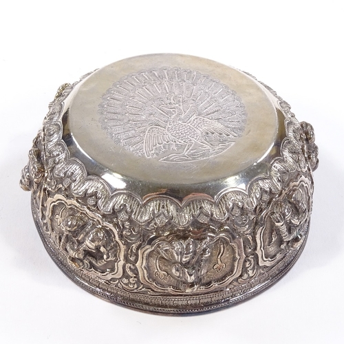 675 - A small Burmese unmarked white metal Thabeik bowl, high relief figural and lotus decoration with eng... 