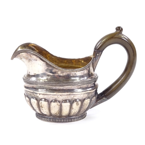 680 - A 19th century Russian silver cream jug, of half fluted form with gadrooned border and a gilt interi... 