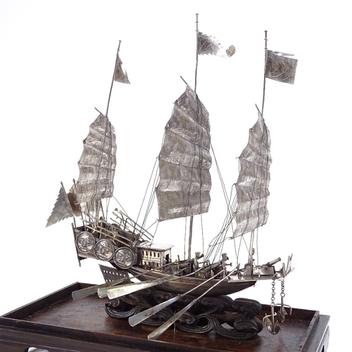 694 - A Chinese silver model junk boat, cannons and moving oars, marked on back of boat and on middle sail... 