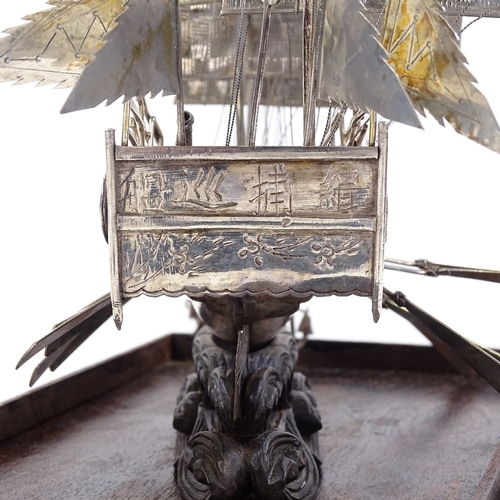 694 - A Chinese silver model junk boat, cannons and moving oars, marked on back of boat and on middle sail... 