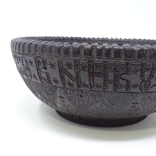 251 - A Russian carved and stained wood bowl, with band of Cyrillic text to the frieze and central engrave... 