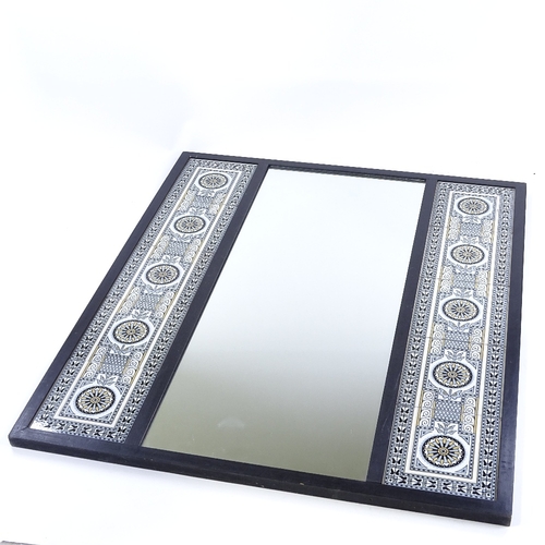 70 - An ebonised wood-framed wall mirror, with 2 inset bands of Minton tiles designed by Dr Christopher D... 