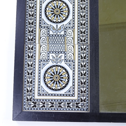 70 - An ebonised wood-framed wall mirror, with 2 inset bands of Minton tiles designed by Dr Christopher D... 