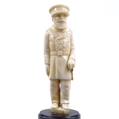 77 - A carved ivory figure of a man in military uniform, unsigned, on turned ebony base, overall height 1... 