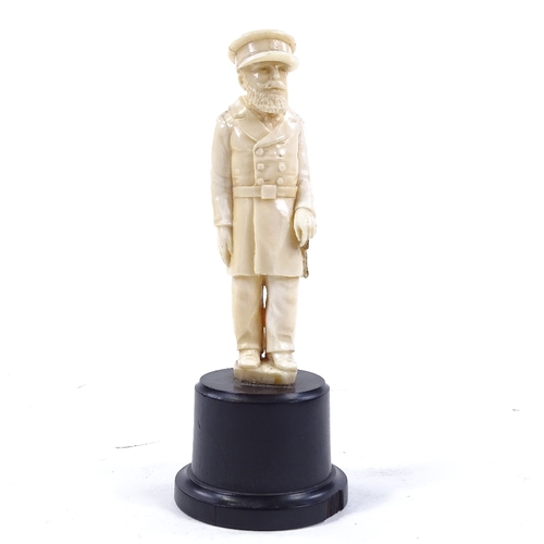 77 - A carved ivory figure of a man in military uniform, unsigned, on turned ebony base, overall height 1... 