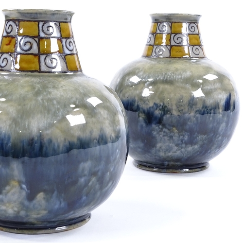 86 - A pair of Royal Doulton squat vases, mottled blue glaze with chequered swirl flared neck, impressed ... 