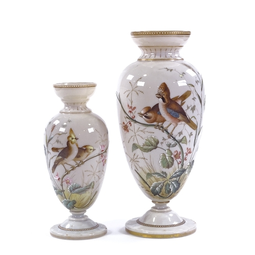 88 - A graduated pair of Victorian milk glass vases, with hand painted designs of exotic birds and flower... 