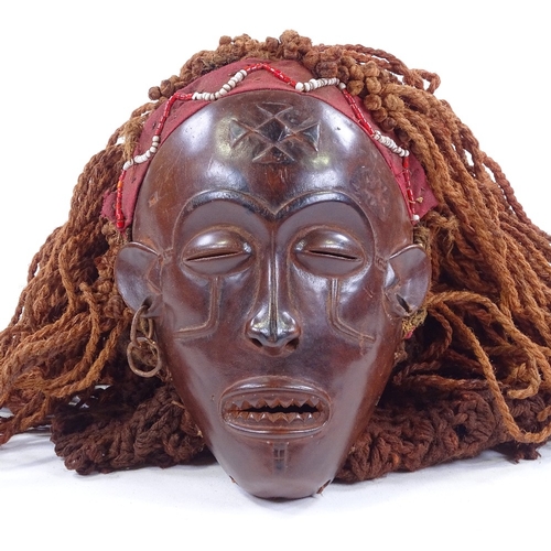 126 - An African carved wood mask with rope braided hair, mask height 19cm