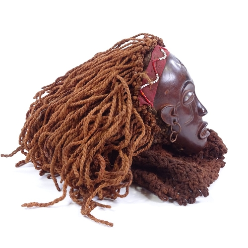 126 - An African carved wood mask with rope braided hair, mask height 19cm