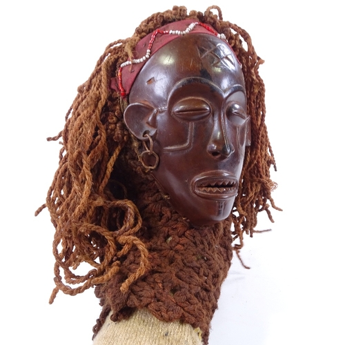 126 - An African carved wood mask with rope braided hair, mask height 19cm