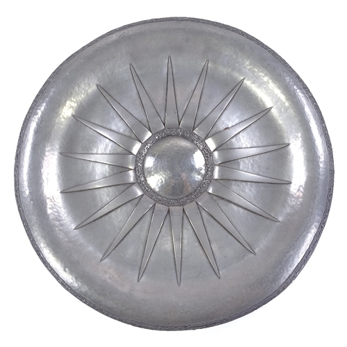 244 - Rene Delavan, large mid-20th century pewter charger, hand beaten with applied sun ray motif, cast ed... 