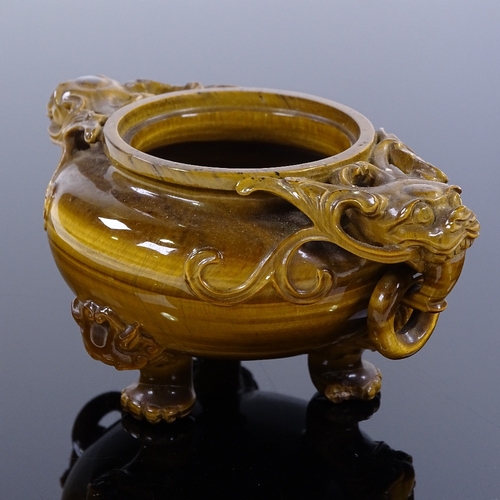 256 - A Chinese pot carved from a single piece of tiger's eye, with dragon ring handles and carved dragon ... 