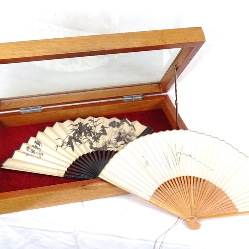 219 - 2 Chinese printed fans, in display case