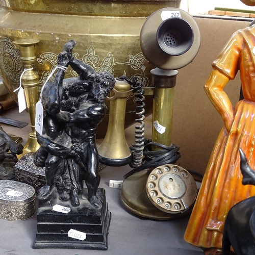 262 - A black painted resin sculpture, depicting intimate wrestlers, and a Vintage brass candlestick telep... 