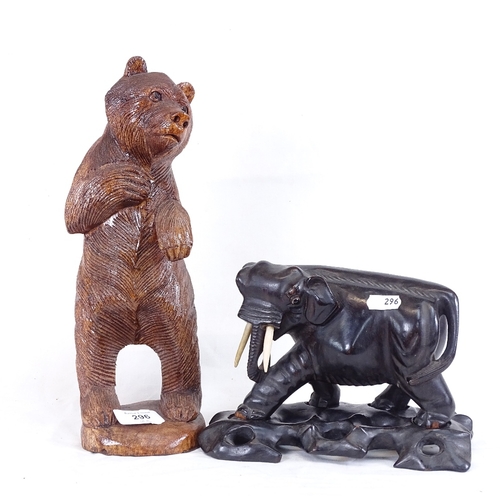 296 - A Black Forest style standing bear carving, and an Oriental carved and stained wood elephant on stan... 