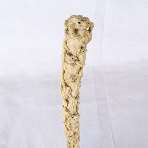 128 - A 19th century relief carved ivory parasol handle, 18ct gold plated collar, handle depicting frogs a... 