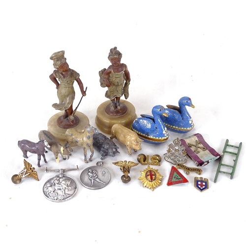 131 - A pair of painted spelter figures on plinths, First War medal, pair of cloisonne enamel swans etc