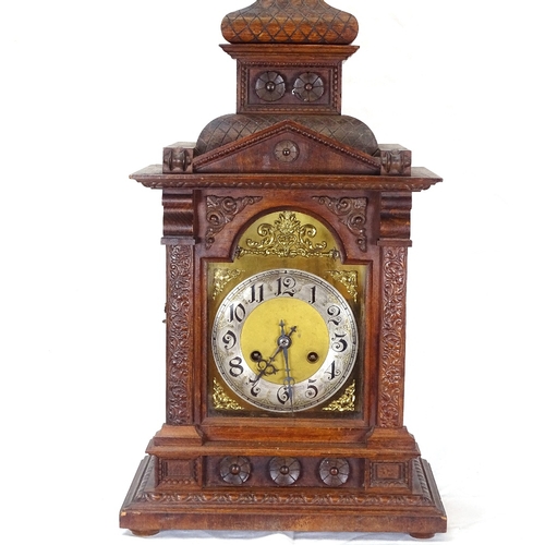 87 - An ornate oak-cased 8-day mantel clock, brass dial with carved floral decoration, overall height 60c... 