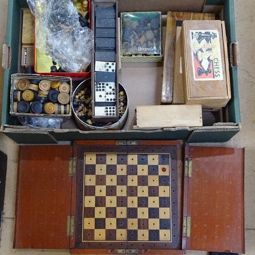 447 - A large quantity of various chess pieces, draughts pieces, dominoes and folding boards