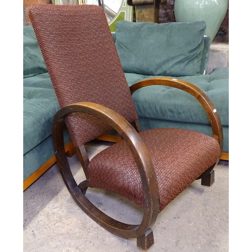 1476 - An Art Deco upholstered and oak-framed rocking chair of stylised form