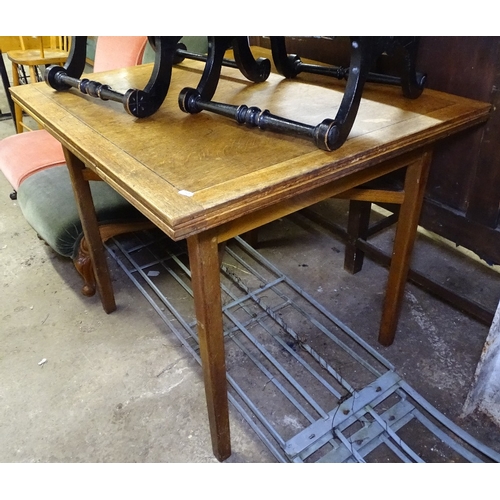 1485 - A 1920s oak Cotswold School style draw leaf dining table