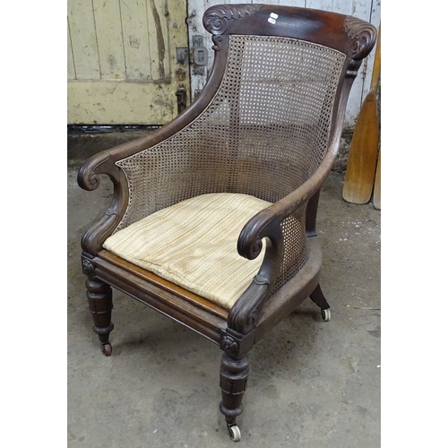 1507 - A William IV mahogany bergere armchair, on tulip carved legs