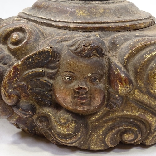 67 - A relief carved painted and gilded wood plinth decorated with cherub masks, probably 18th century, w... 