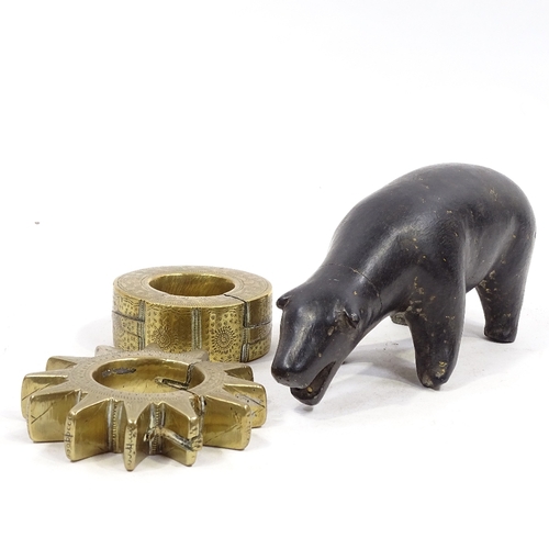 75 - An Inuit carved stone polar bear, length 22cm, and 2 unusual Middle Eastern bronze disc padlocks (3)