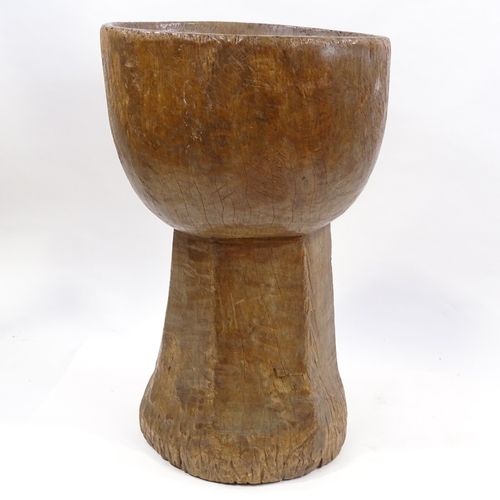 79 - A floor standing Tribal mortar bowl, carved from a single piece of wood, height 73cm, diameter 47cm