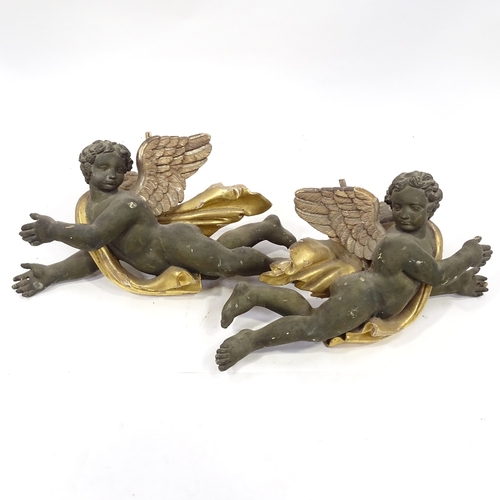 94 - A pair of 19th century carved painted and gilded wood flying cherub ornaments, length 68cm