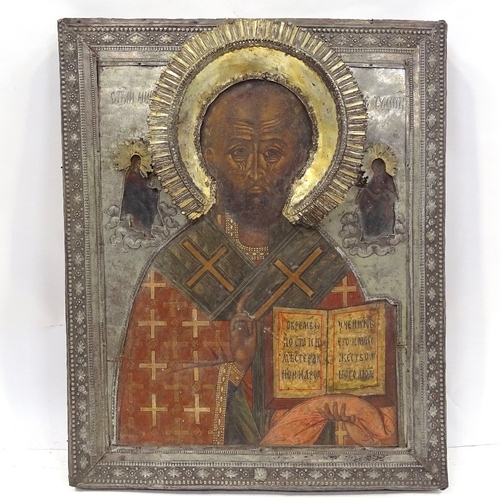 104 - A Russian silver-fronted icon, 18th or 19th century, painted portrait of a saint with Cyrillic inscr... 