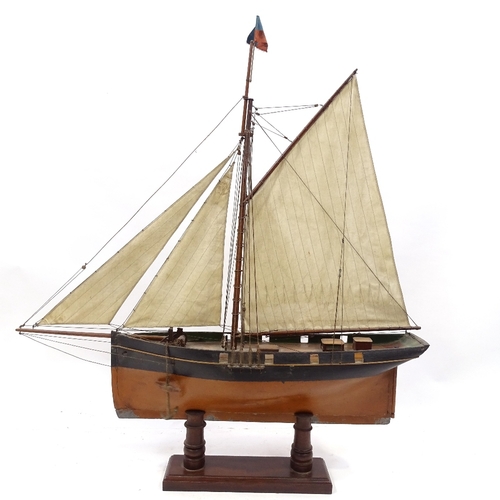 123 - A Victorian painted wood hulled model pond yacht, with sales and rigging, hull length 57cm, on woode... 