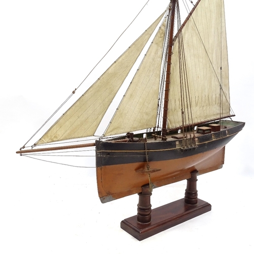 123 - A Victorian painted wood hulled model pond yacht, with sales and rigging, hull length 57cm, on woode... 