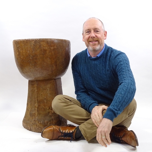 79 - A floor standing Tribal mortar bowl, carved from a single piece of wood, height 73cm, diameter 47cm