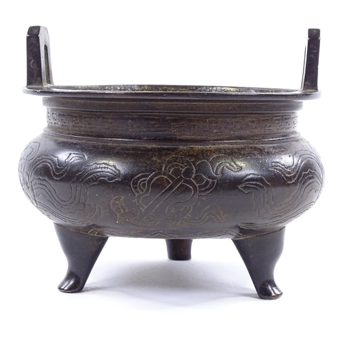 146 - A Chinese patinated bronze 2-handled Ding incense burner, with incised decoration and 6 character se... 