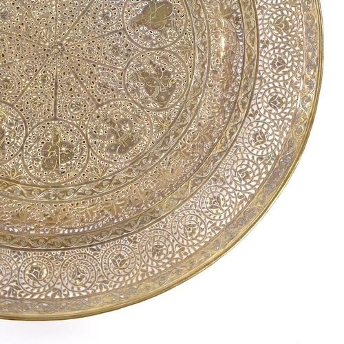 149 - An ornate Middle Eastern brass plate, with pierced and engraved decoration, diameter 23cm