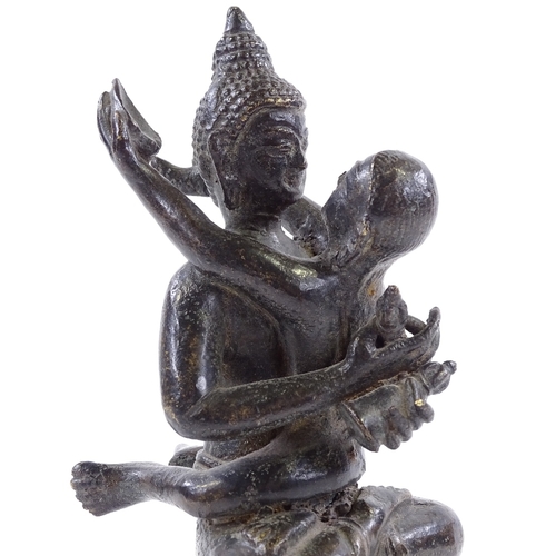 393 - An Indian bronze figure of Buddha holding a child, height 17cm