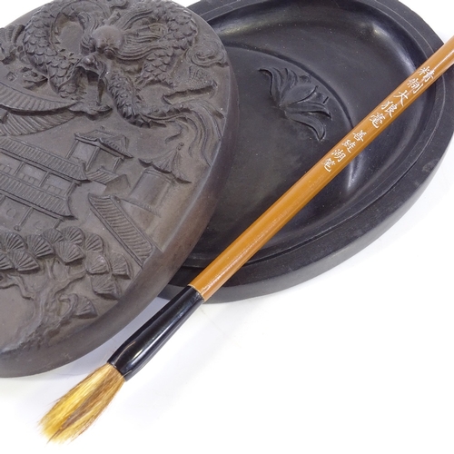 400 - A Chinese ink stone and cover, with relief moulded lid, length 14cm, and brush