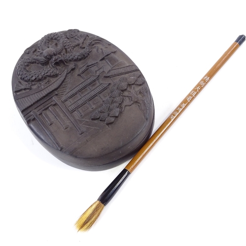 400 - A Chinese ink stone and cover, with relief moulded lid, length 14cm, and brush