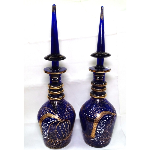 522 - A pair of Bristol blue glass decanters with enamelled and gilded decoration, 49cm