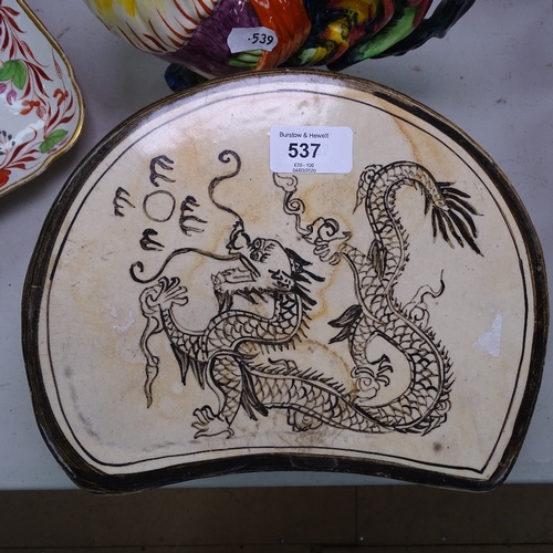 537 - A ceramic Chinese pillow with dragon decoration, 23cm across