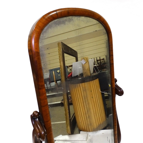 434 - A Victorian mahogany cheval mirror with arched top, on carved and scroll supports