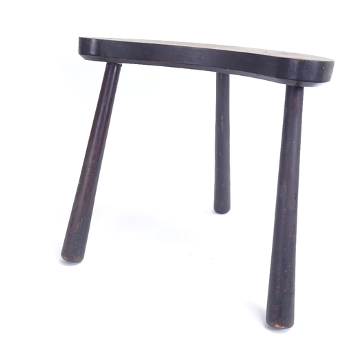 23 - A stained and penned hardwood curved tripod stool, height 36cm