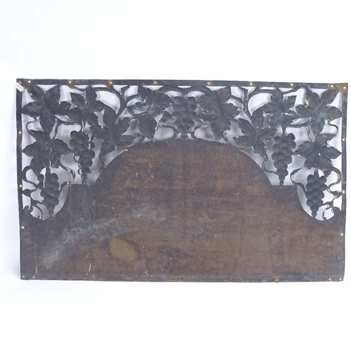 25 - An Art Nouveau copper door pediment, pierced grapevine decoration and planished central panel, lengt... 